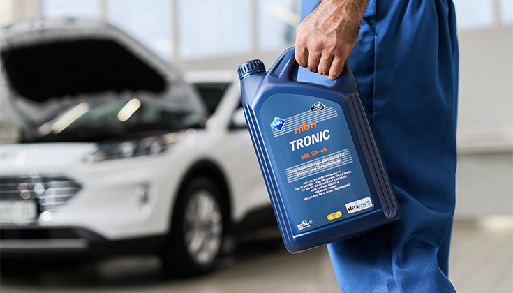 Механік тримає каністру моторної оливи Aral Tronic